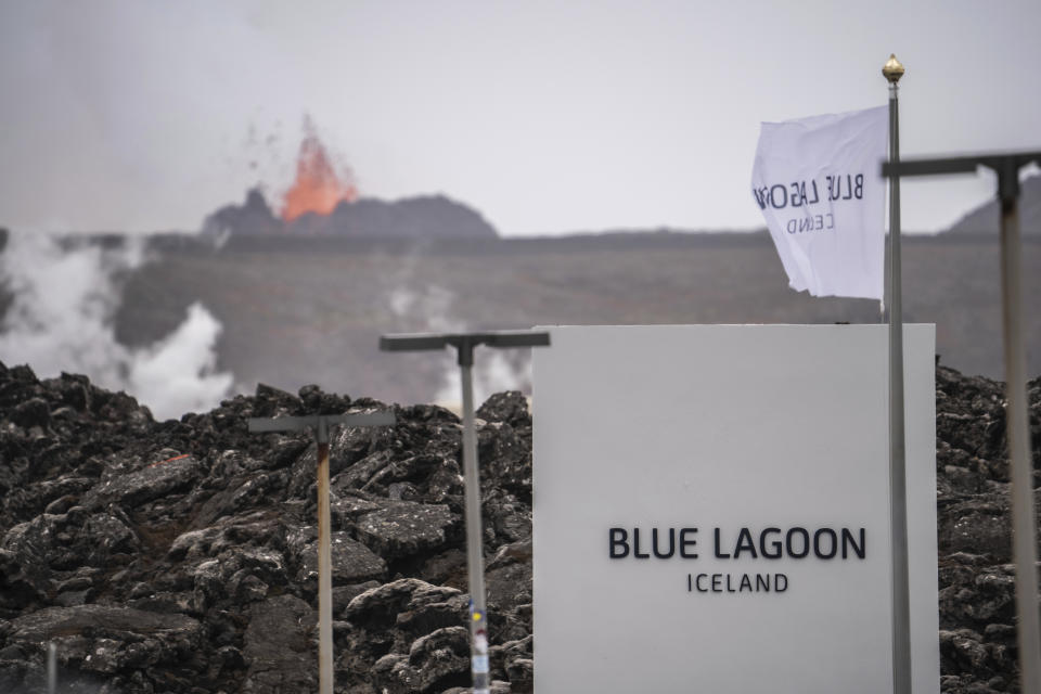 The entrance of the Blue Lagoon as the volcan0 erupts in the background in Grindavik, Iceland, Sunday, June 2, 2024. The popular Blue Lagoon geothermal spa, one of Iceland’s biggest tourist attractions in the country's southwest, was reopened Sunday after authorities said a nearby volcano had stabilized after erupting four days earlier. (AP Photo/Marco di Marco)