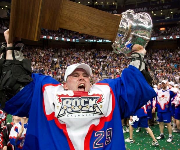 In this May 15, 2011 file photo, Toronto Rock goaltender Bob Watson hoists the National Lacrosse League trophy. The team announced Tuesday that it will play its home games in Hamilton. (Frank Gunn/The Canadian Press - image credit)