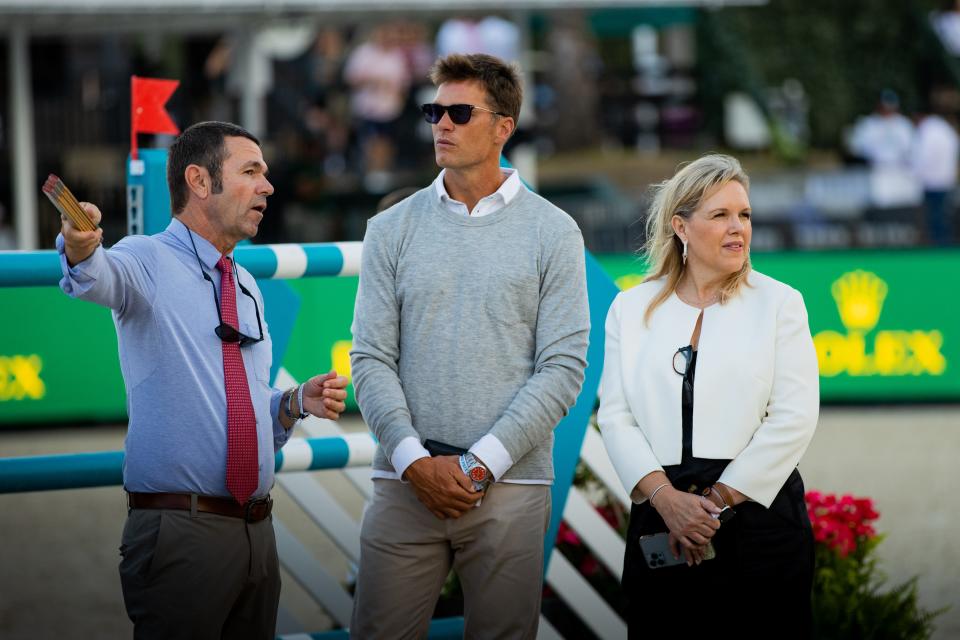 Tom Brady is escorted around the course for the $500,000 Rolex Grand Prix at Wellington International last Saturday night by Jorge Guilherme (left) and Melissa Brandes.