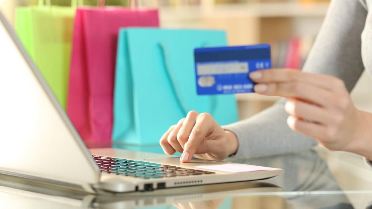 Shopper hands buying with credit card on laptop.