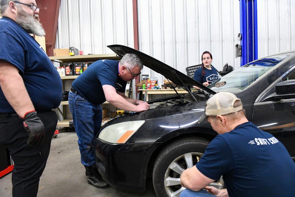 SHIFT Garage volunteers Greg Matson, Jim Johnson, Jen Roeder and Chad Huston work to spruce up a donated car on Wednesday, January 12, 2022, in Sioux Falls.