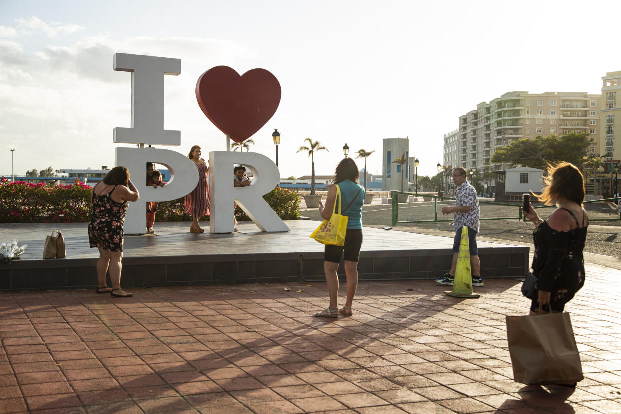 Personas toman fotografías cerca de los muelles de cruceros en el sur del Viejo San Juan, en San Juan, Puerto Rico, el 21 de abril de 2021. (Erika P. Rodriguez/The New York Times)