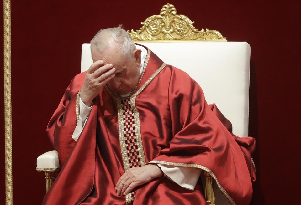 Pope Francis touches his forehead as he celebrates Mass for the Passion of Christ, in St. Peter's Basilica, at the Vatican, Friday, April 19, 2019. Pope Francis began the Good Friday service at the Vatican with the Passion of Christ Mass and hours later will go to the ancient Colosseum in Rome for the traditional Way of the Cross procession. (AP Photo/Alessandra Tarantino)