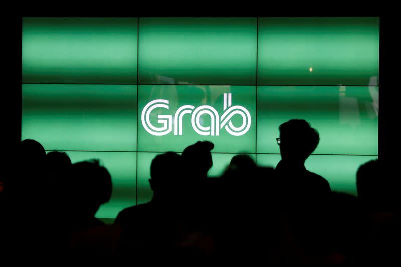 FILE PHOTO: People wait for the start of Grab's fifth anniversary news conference in Singapore