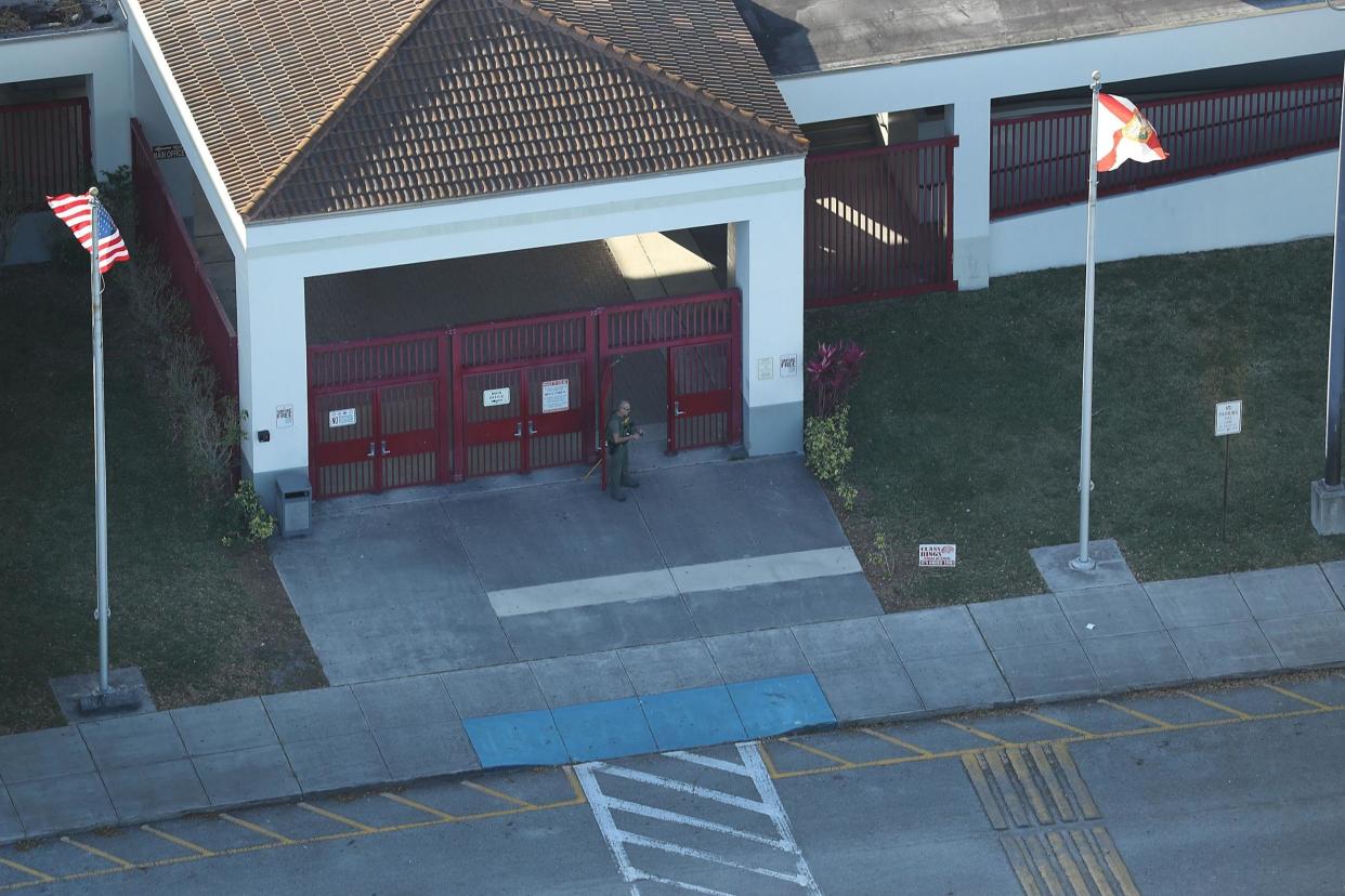 A law enforcement officer stands at the front door of the Marjory Stoneman Douglas High School after a shooting: Joe Raedle/Getty Images