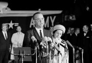 The new president of the United States, Lyndon B. Johnson, speaks at Andrews Air Force Base upon his return to Washington from Dallas, where President John F. Kennedy was shot to death, Nov. 22, 1963. Beside him is new first lady, Lady Bird Johnson. (Photo: AP)