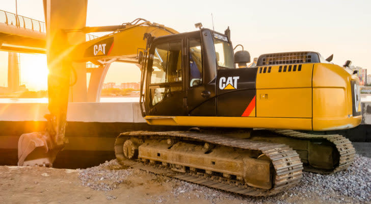 Caterpillar (CAT) excavator vehicle backlit by sunset