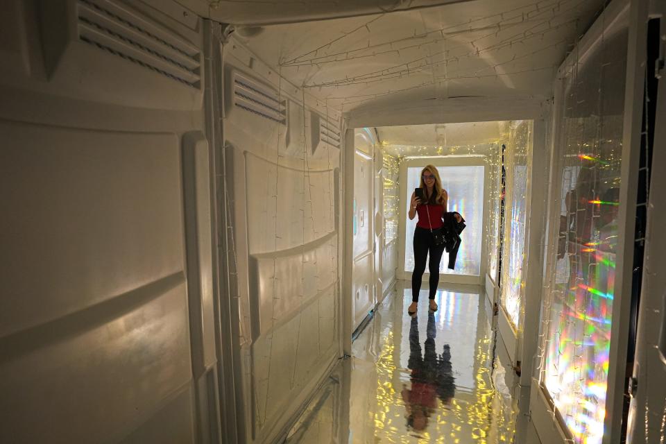 Madeline Hollern takes photos inside the "Portal Potty" installation at the Waterloo Greenway Creek Show on Nov. 10.