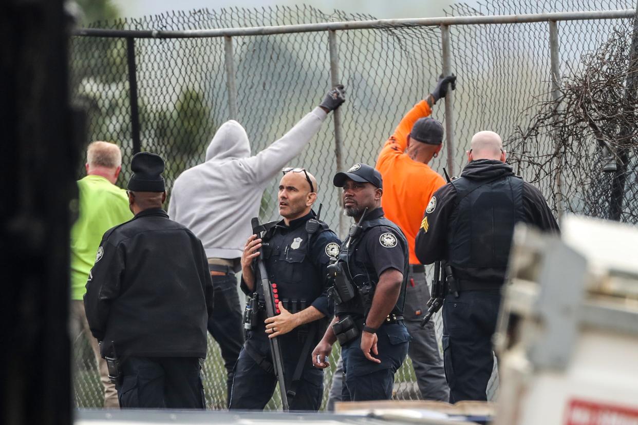 Atlanta police and construction personnel stand near damaged property at the Atlanta Public Safety Training Center in DeKalb County, Ga., Monday, March 6. More than 20 people from around the country faced domestic terrorism charges Monday after dozens of young men in black masks attacked the site of a police training center under construction in a wooded area outside Atlanta where one protester was killed in January.