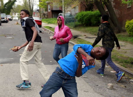 Demonstrators throw rocks at Baltimore police during clashes in Baltimore, Maryland April 27, 2015. REUTERS/Shannon Stapleton