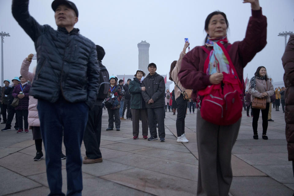 Tourists take photos of the daily flag raising ceremony at Tiananmen Square on the eve of the opening session of China's National People's Congress (NPC) in Beijing, Tuesday, March 5, 2019. A year since removing any legal barrier to remaining China's leader for life, Xi Jinping appears firmly in charge, despite a slowing economy, an ongoing trade war with the U.S. and rumbles of discontent over his concentration of power. (AP Photo/Mark Schiefelbein)