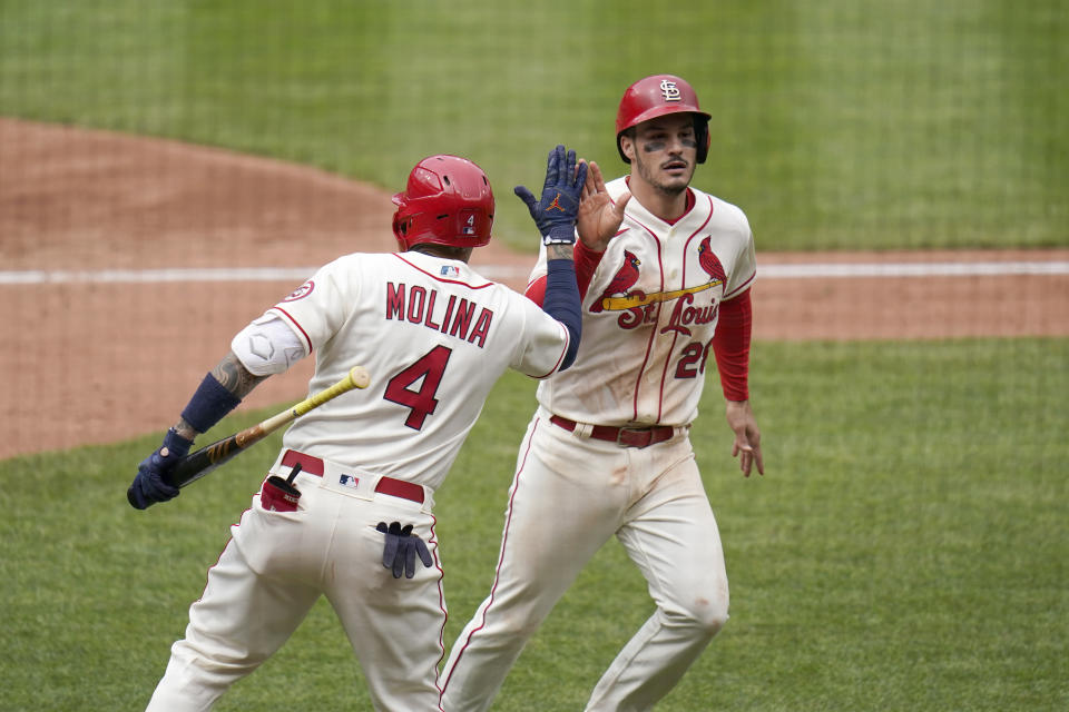 St. Louis Cardinals' Nolan Arenado, right, is congratulated by teammate Yadier Molina (4) after scoring during the fifth inning of a baseball game against the Colorado Rockies Saturday, May 8, 2021, in St. Louis. (AP Photo/Jeff Roberson)