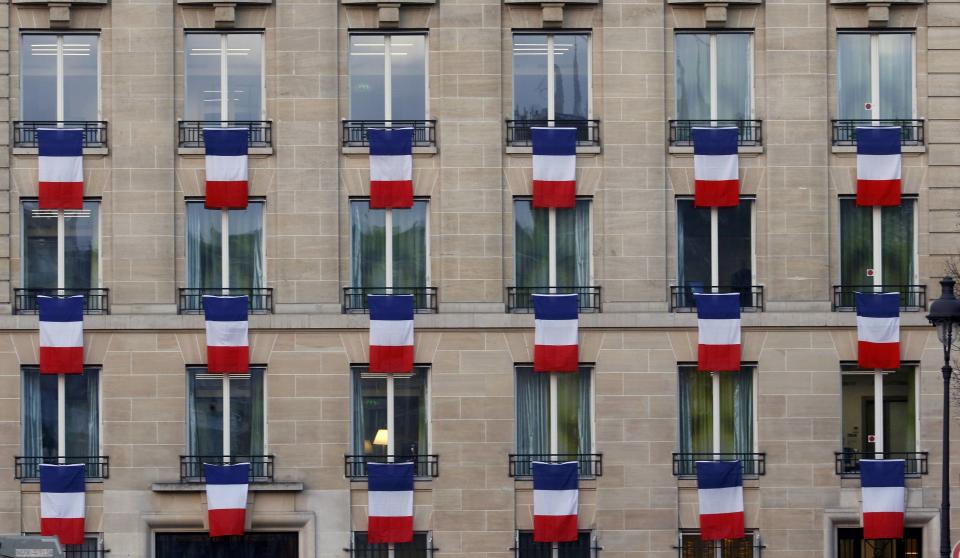 French flags hang from windows of a building near the Invalides in Paris, France, November 27, 2015. The French President called on all French citizens to hang the tricolour national flag from their windows on Friday to pay tribute to the victims of the Paris attacks during a national day of homage. (REUTERS/Jacky Naegelen)