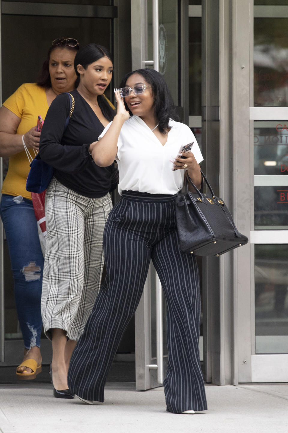 Azriel Clary, right, and Joycelyn Savage, two women who lived in Chicago with R&B singer R. Kelly, leave at Brooklyn federal court following his arraignment, Friday, Aug. 2, 2019 in New York. Kelly pleaded not guilty Friday to federal charges he sexually abused women and girls. The 52-year-old Kelly was denied bail in a Brooklyn courtroom packed with his supporters. (AP Photo/Mark Lennihan)