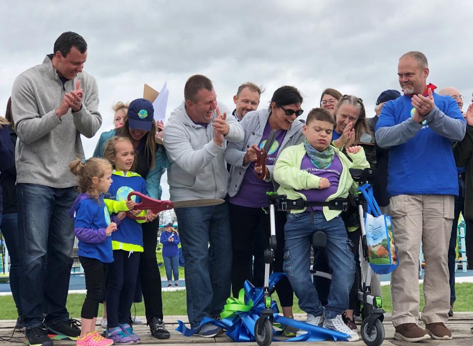 MJ Bentley, mom and dad Nanci and Mike Bentley and many others officially open the Motion Junction playground in the town of Canandaigua during a ribbon-cutting ceremony Saturday.