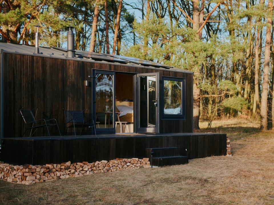 A Raus cabin in nature surrounded by tall trees.