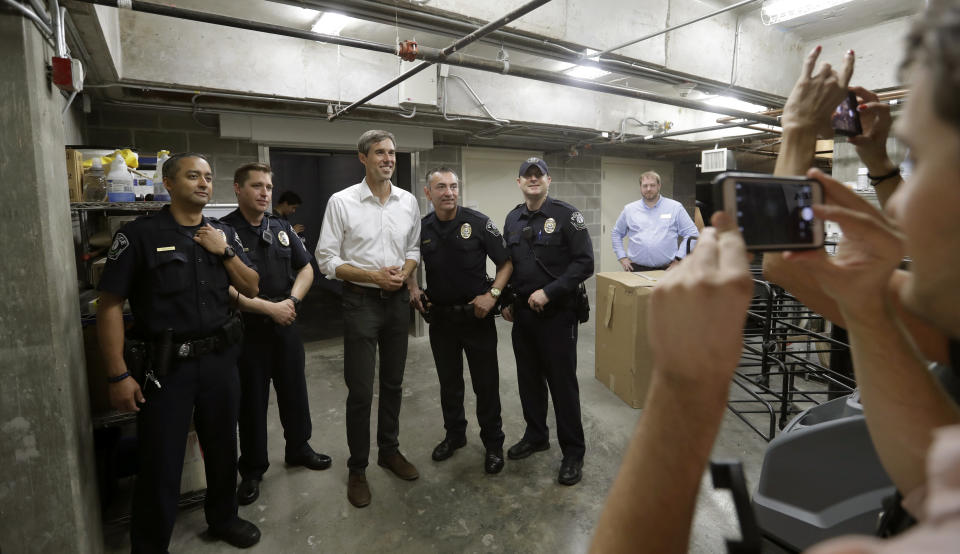 In this Tuesday, Oct. 2, 2018 photo, Democratic Senate candidate Rep. Beto O'Rourke, center in white shirt, poses for a photo with campus police following a campaign stop at Austin Community College Eastview, in Austin, Texas. O'Rourke has risen to national prominence on a workaday image that aligns closely with his politics but not his family's actual finances. (AP Photo/Eric Gay)