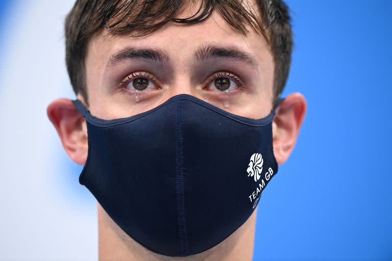 Lágrimas en los ojos de los medallistas de oro británico Thomas Daley y Matty Lee de Gran Bretaña (invisible) mientras esperan recibir sus medallas después de ganar el evento final masculino de clavados sincronizados de plataforma de 10 metros durante los Juegos Olímpicos de Tokio 2020 en el Centro Acuático de Tokio en Tokio en julio. 26 de febrero de 2021.