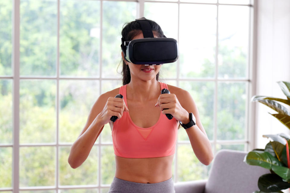 A woman wearing a black virtual reality headset during a sport workout routine (Image: Getty Images)