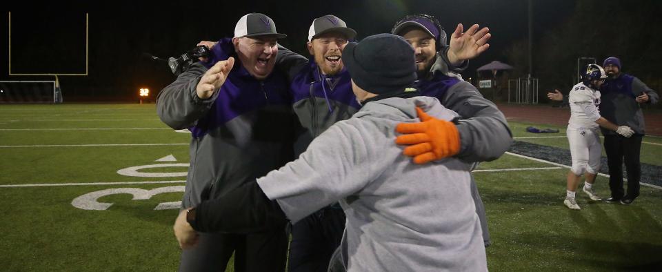 North Kitsap coaches (clockwise from left) Jeff Weible, Jared Prince, Chris Richardson and Dave Snyder embrace after their 29-22 win over W.F. West in Tumwater on Saturday, Nov. 26, 2022. 