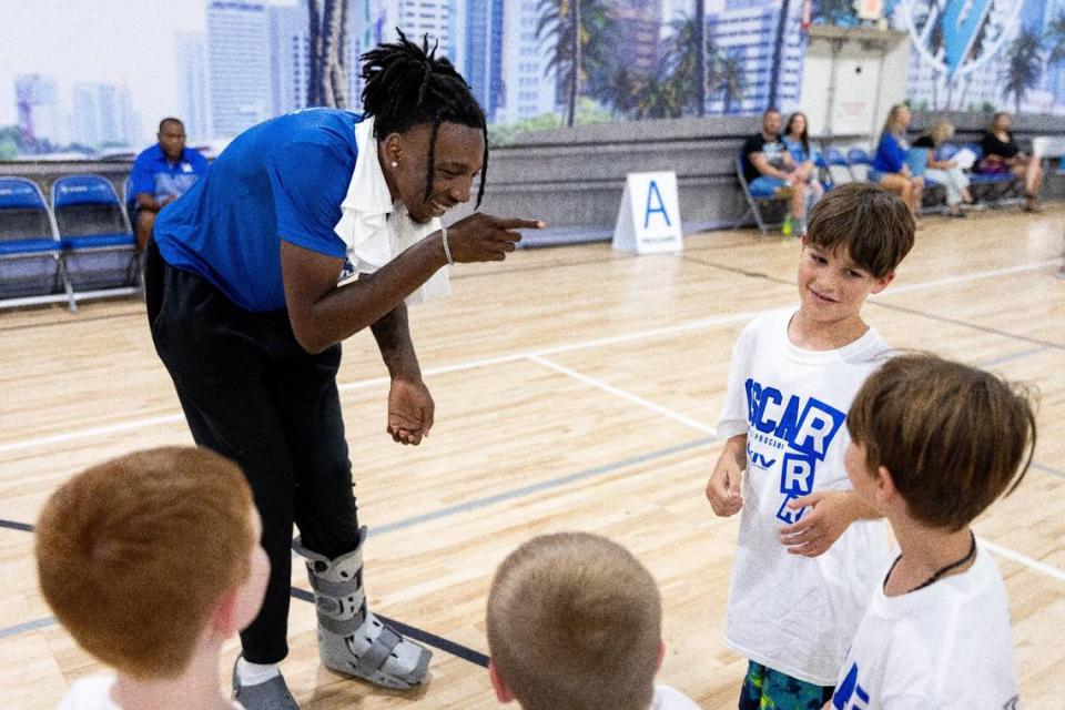 Kentucky freshman Aaron Bradshaw plays Rock, Paper, Scissors with a camper during Oscar Tshiebwe’s youth basketball camp at Sports Center in Lexington on Sunday.