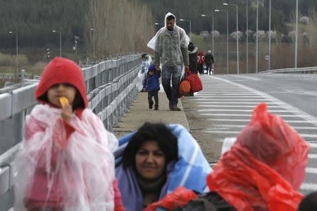 Migrants walk along a road towards a makeshift camp at the Greek-Macedonian border, near the Greek village of Idomeni, Greece March 4, 2016. REUTERS/Marko Djurica