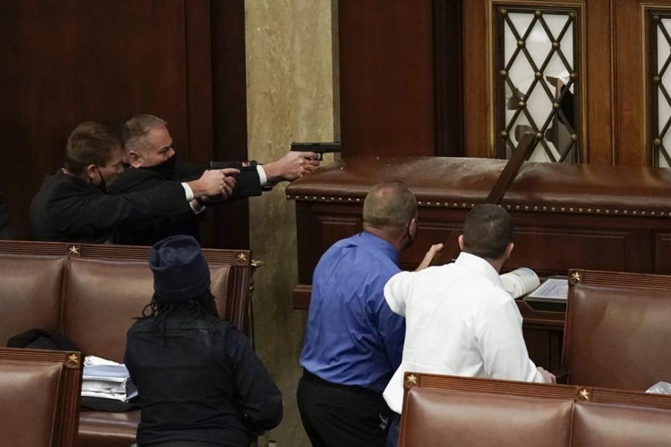 U.S. Capitol Police with guns drawn watch as protesters try to break into the House Chamber at the U.S. Capitol on Wednesday, Jan. 6, 2021, in Washington. (AP Photo/J. Scott Applewhite)