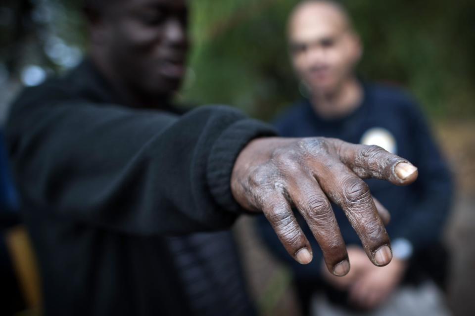 In this Monday, Dec. 9, 2013 photo, a homeless man talks to Homeless Liaison Officer Tom Gentner about new people who arrived to a nearby campsite in Savannah, Ga. Gentner has built a relationship of trust with the homeless population around Savannah. They keep him informed about camp activities and he addresses their needs as they arise. Gentner's duties include settling disputes, documenting camp residents and checking their criminal backgrounds. (AP Photo/Stephen B. Morton)