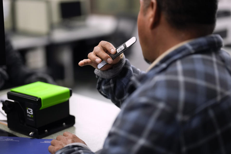 A man uses a swab to collect a sample while being detained at an immigration and customs processing facility, Wednesday, March 15, 2023, in San Diego. Some asylum-seekers who crossed the border from Mexico are waiting 10 years just for a court date. The Border Patrol released people with notices to appear at a U.S. Immigration and Customs Enforcement office. The move saved the Border Patrol untold hours processing court papers, but it left the job to an agency that had no extra staff for the increased workload. (AP Photo/Gregory Bull)