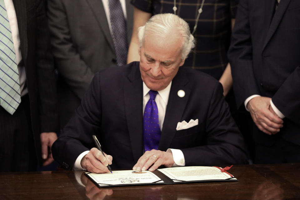 South Carolina Gov. Henry McMaster signs a ceremonial copy of a bill allowing anyone who can legally own a gun to openly carry the weapon in the state at an event on Tuesday, March 19, 2024, in Columbia, S.C.. McMaster signed the bill into law March 7. (AP Photo/Jeffrey Collins)