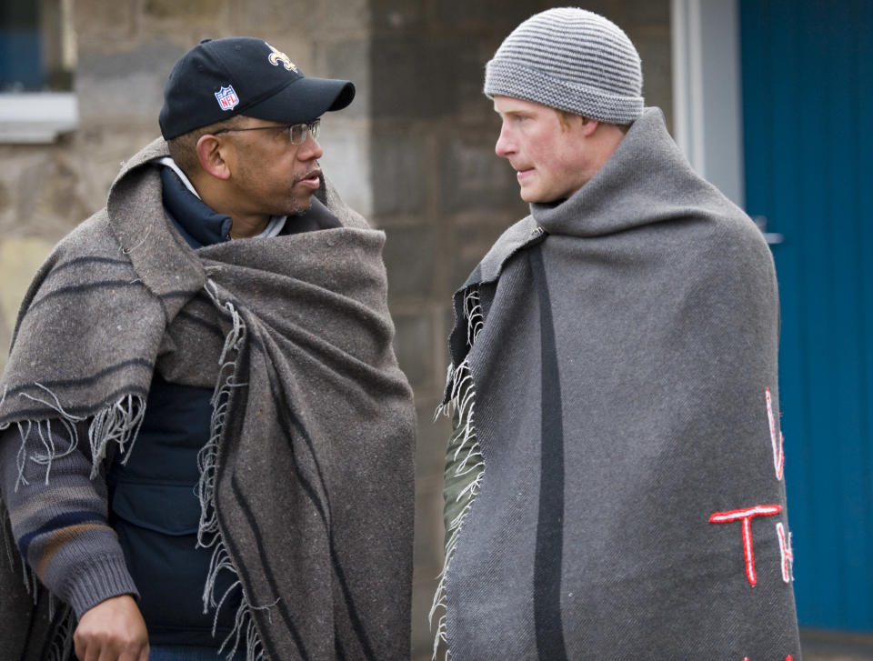 Britain's Prince Harry, right, is presented with a specially embroidered traditional blanket, by Lesotho's Prince Seeiso, before visiting a school for local herd boys opened by Sentebale, a charity for disadvantaged Lesotho youngsters, co-founded by the two Princes, in the remote village of Semongkong, Lesotho.