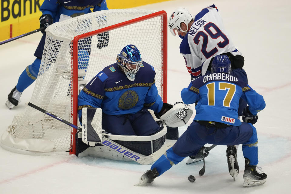 Kazakhstan's goalkeeper Nikita Boyarkin, center, makes a save in front of Unted States' Brock Nelson during the preliminary round match between United States and Kazakhstan at the Ice Hockey World Championships in Ostrava, Czech Republic, Sunday, May 19, 2024. (AP Photo/Darko Vojinovic)