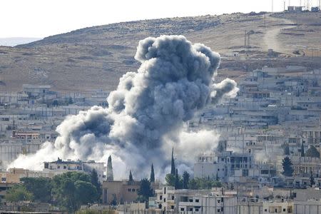 Smoke rises from the Syrian town of Kobani, seen from near the Mursitpinar border crossing on the Turkish-Syrian border in the southeastern town of Suruc in Sanliurfa province October 15, 2014. REUTERS/Kai Pfaffenbach