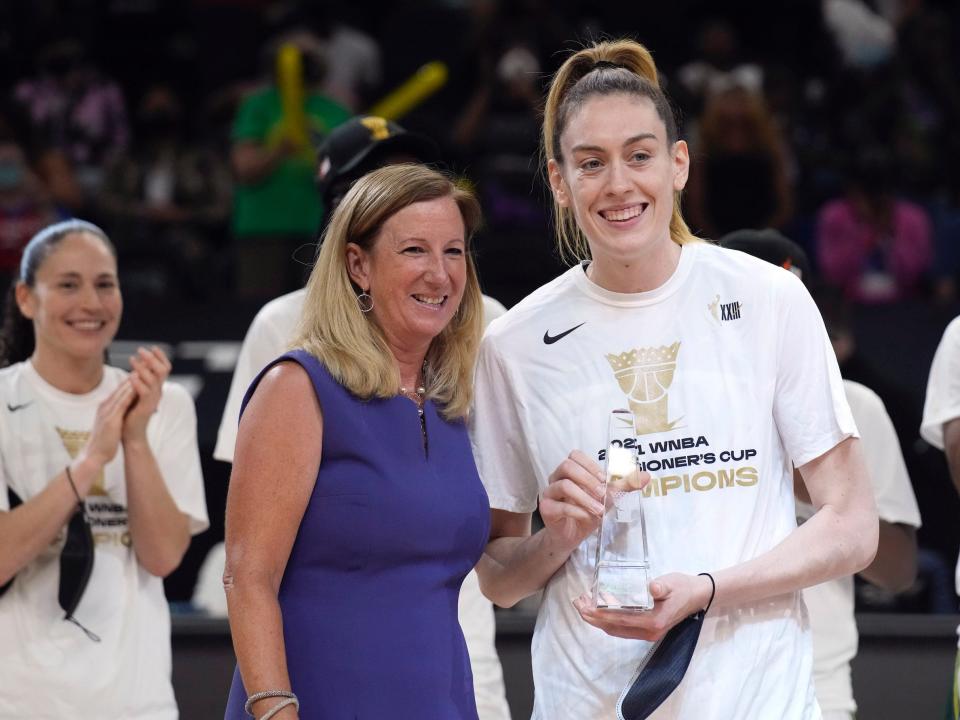 Breanna Stewart (right) holds her Commissioner's Cup MVP trophy while posing alongside WNBA Commissioner Cathy Engelbert.
