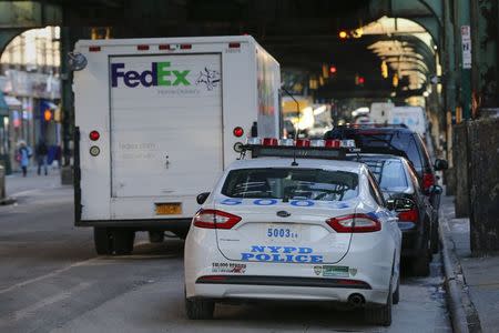 A NYPD patrol car sits parked behind an illegally parked FedEx truck in the Queens borough of New York January 7, 2015. REUTERS/Shannon Stapleton