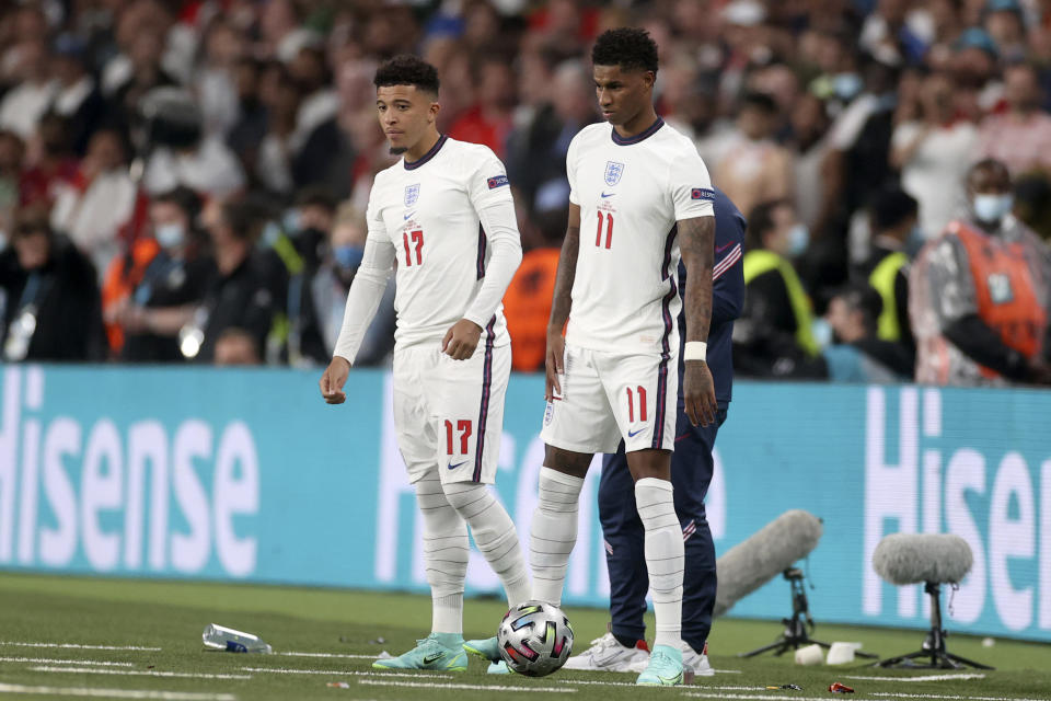 FILE - England's Jadon Sancho and Marcus Rashford, right, get ready to enter the pitch during the Euro 2020 soccer championship final soccer match between England and Italy at Wembley stadium in London, Sunday, July 11, 2021. Black players like Marcus Rashford and Bukayo Saka have flourished even after being targeted online for missing penalties in England's shootout loss to Italy in the European Championship final in 2020. But a third Black player who also missed a penalty and was racially abused, Jadon Sancho, has struggled on the field ever since. (Carl Recine/Pool Photo via AP, File)
