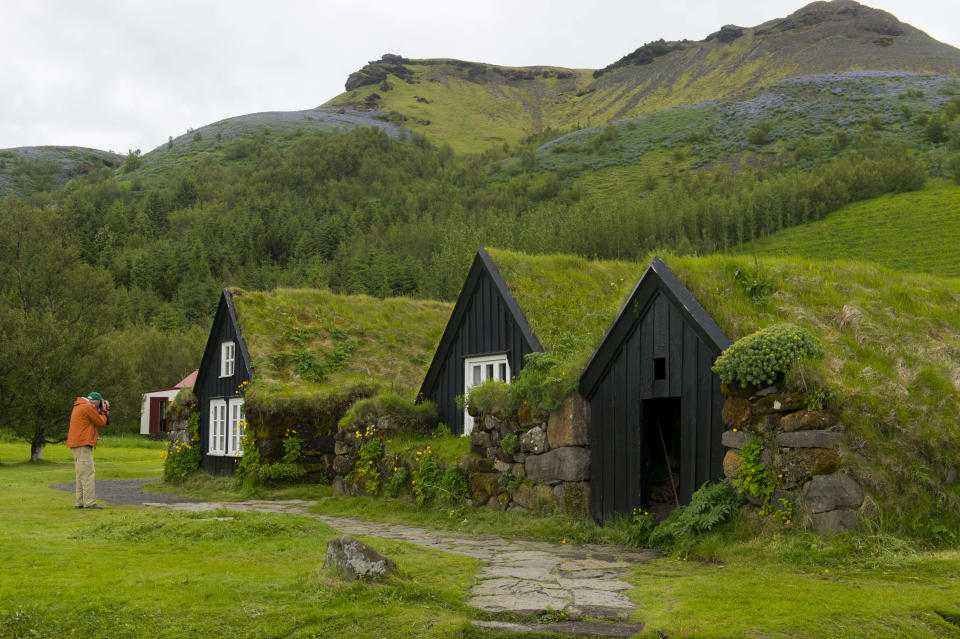 ICELAND – 2017/06/30: Tourist photographing traditional turf houses at the Skogar folk museum in southern Iceland. (Photo by Wolfgang Kaehler/LightRocket via Getty Images)