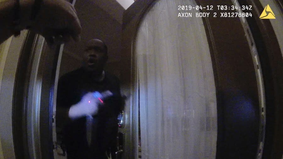 In this image from Ocoee Police Department body-camera video, Samuel Celestin holds a knife and a remote control as officers confront him at the front door of his home in Ocoee, Fla., on April 11, 2019. As police arrived at the scene, his sister, Joanne, explained that her brother had been diagnosed with schizophrenia and bipolar disorder, and had been removed from the house before by an intervention unit. (Ocoee Police Department via AP)