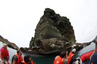 Tourists ride a boat as they look at the pinnacle rock at Bartolome Island in Galapagos August 23, 2013. (REUTERS/Jorge Silva)