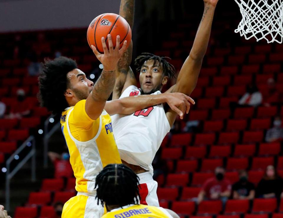 Pittsburgh’s Justin Champagnie (11) heads to the basket as N.C. State’s Manny Bates (15) defends during the first half of N.C. State’s game against Pittsburgh at PNC Arena in Raleigh, N.C., Sunday, February 28, 2021.