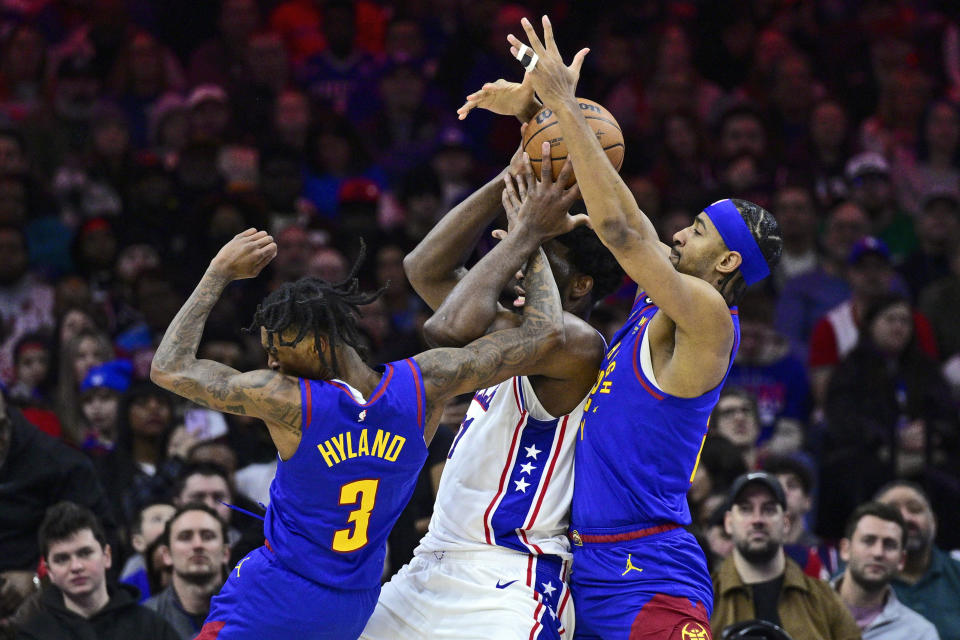 Philadelphia 76ers' Joel Embiid, center, is double-teamed by Denver Nuggets' Bones Hyland (3) and Zeke Nnaji during the first half of an NBA basketball game, Saturday, Jan. 28, 2023, in Philadelphia. (AP Photo/Derik Hamilton)