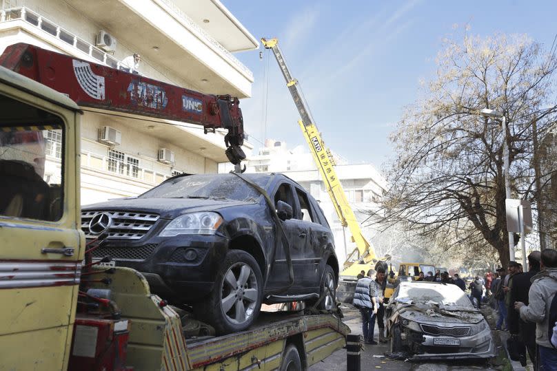 Emergency services work at a building hit by an air strike in Damascus, Syria on Saturday