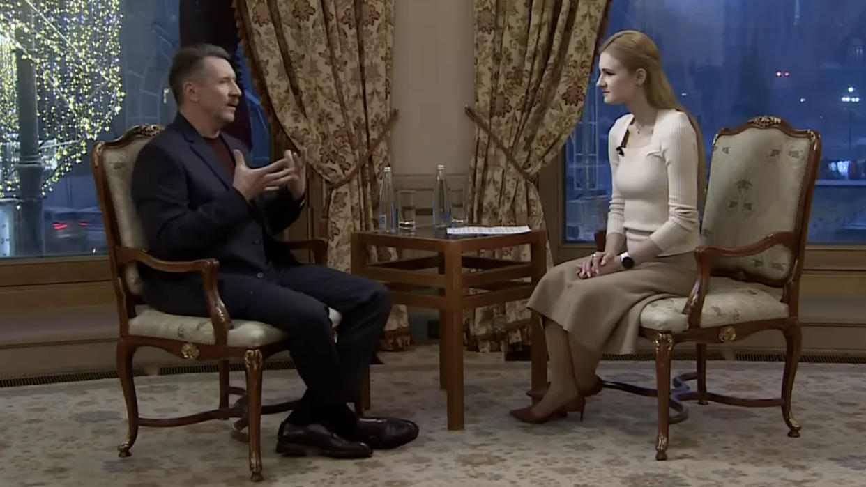 Viktor Bout and Marina Butina sit across from each other during a television interview..