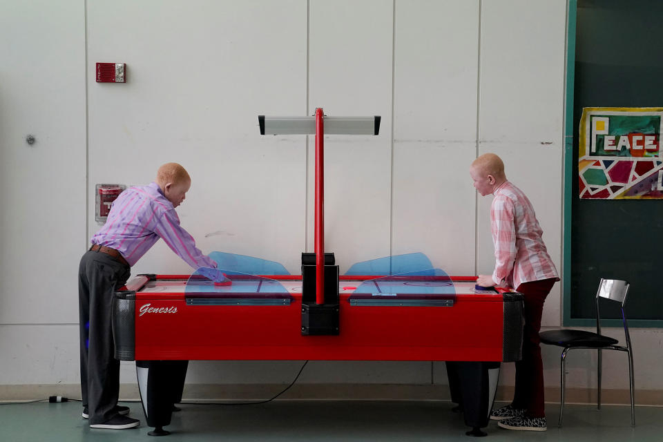 Emmanuel Rutema and Pendo Noni play air hockey