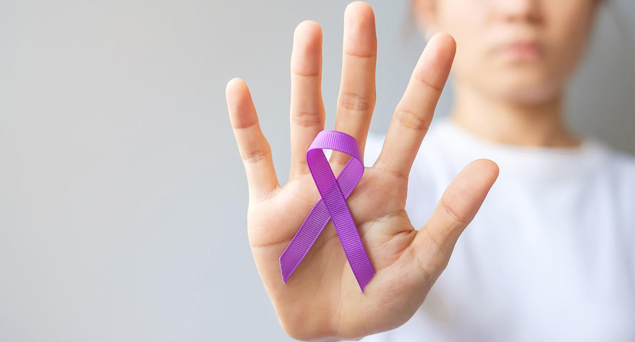 Woman showing purple ribbon, to represent epilepsy day. (Getty Images)