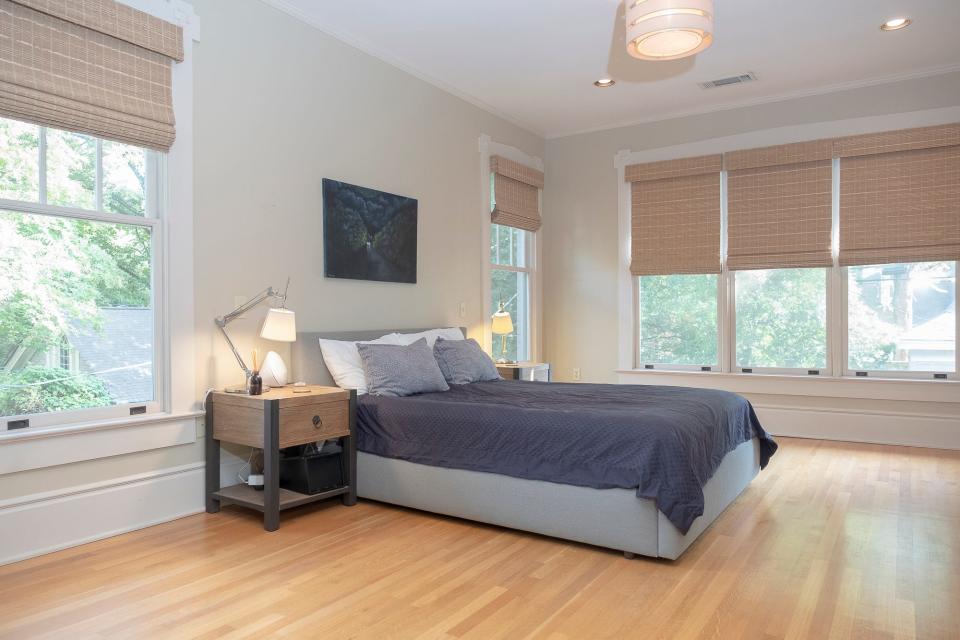 The primary bedroom is large and has plenty of natural light thanks to large windows on adjacent walls.