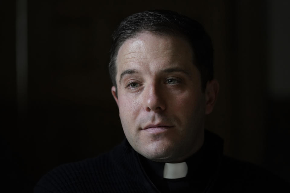 Father Matthew Hood is shown at Our Lady of the Rosary church Friday, Feb. 18, 2022, in Detroit. In 2020, one word caught the ear of a young Detroit-area priest while he watched a video of his baptism from decades earlier. "Wait," the Rev. Matthew Hood recalled thinking. "Something doesn't seem right here." Indeed, an error by a deacon had spoiled the sacrament — and, in domino-like fashion, meant he truly wasn't a priest. (AP Photo/Paul Sancya)