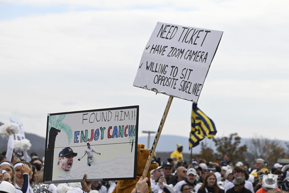 Fans display signs about Michigan head coach Jim Harbaugh outside of Beaver Stadium before an NCAA college football game against Penn State, Saturday, Nov. 11, 2023, in State College, Pa. (AP Photo/Barry Reeger)