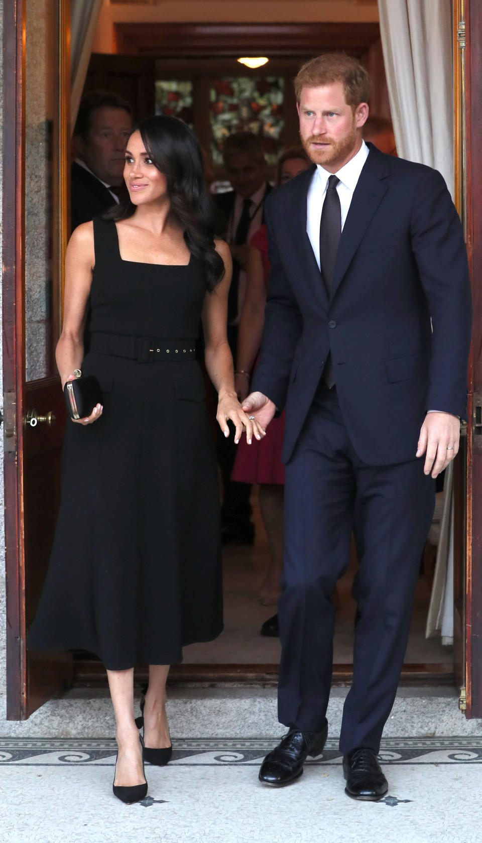 For a summer party at Glencairn House, the Duchess of Sussex changed into a black belted midi dress by Emilia Wickstead [Photo: Getty]