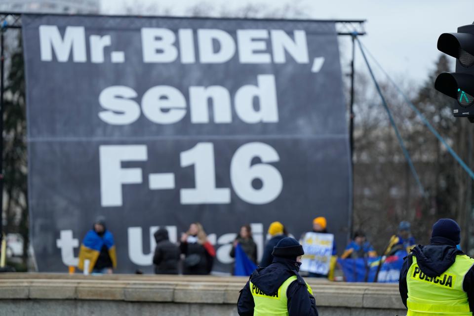 A small group of protestors urge U.S. President Joe Biden to send fighter jets to the Ukraine, outside his hotel in Warsaw, Poland, Wednesday, Feb. 22, 2023.